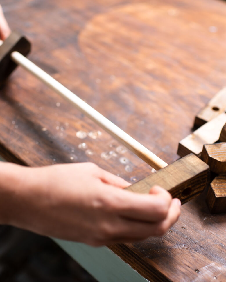 Sliding each of the timber pieces onto the dowel